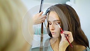 Makeup artist and hairstylist prepare model woman for fashion show slow motion