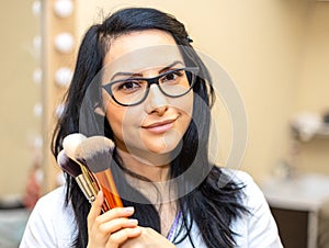 Makeup artist holding brushes. Makeover. Perfect Skin photo