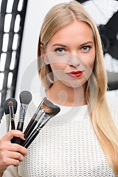 Makeup artist showing professional brushes