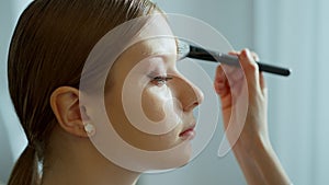 Makeup artist work in her beauty studio. Portrait of Woman applying by professional make up master.