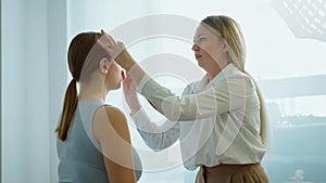 Makeup artist work in her beauty studio. Portrait of Woman applying by professional make up master.