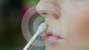 Makeup artist work in her beauty studio. Portrait of woman applying by professional make up master.