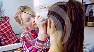 Makeup artist at work. Makeup model.