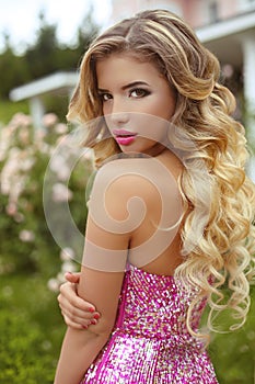 Makeup. Beautiful girl with blond long wavy hair posing in Fashi photo