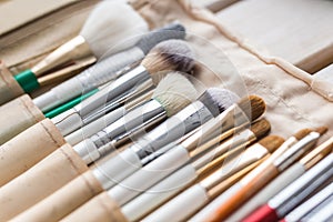 Makeup, beauty and cosmetics concept - Set of make-up brushes in a light case.