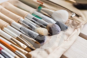 Makeup, beauty and cosmetics concept - Set of make-up brushes in a light case.