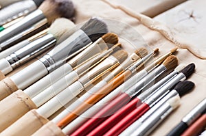 Makeup, beauty and cosmetics concept - Set of make-up brushes in a light case.