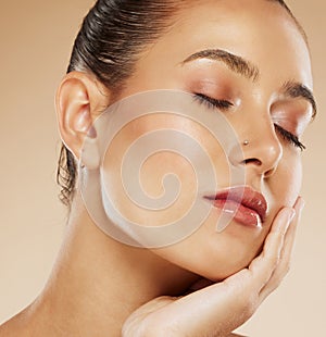 Makeup, beauty and face of a woman with a glow from cosmetics against a brown studio background. Skin, care and young