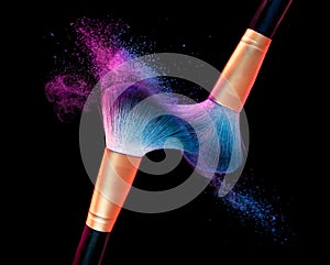 Makeup brush with blue powder explosion on black photo