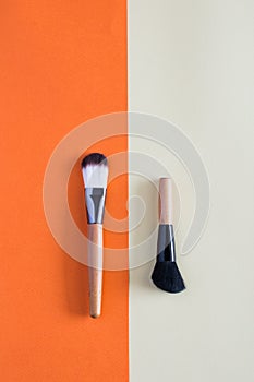 Makeup brush and cosmetics on colorful backgrounds