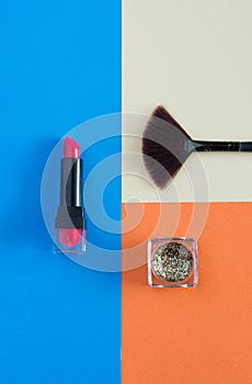 Makeup brush and cosmetics on colorful backgrounds