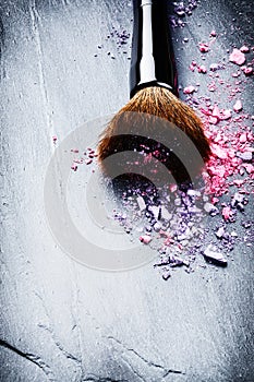 Makeup brush and crushed eye shadows