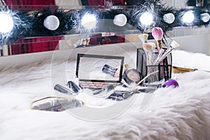 Makeup brush and glass on white fur backdrop, Beauty concept