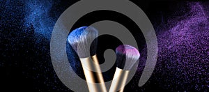 Makeup brush with pink and blue powder explosion