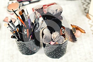 Makeup brushes, closeup. Collection of professional makeup tools, top view. Creative background with make up brushes kit. Beauty,