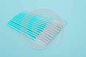 Makeup brushes, eyelash combs and eyebrows on blue background with copy space