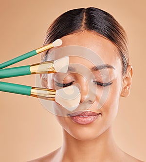 Makeup brushes, eyes closed or girl with facial self care or beauty cosmetics on studio background. Face model, smile or