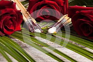 Makeup brushes next to roses