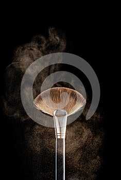 Makeup brushes, with scattering powder, isolated on black background