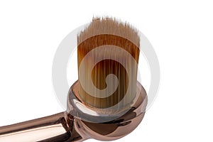 Makeup brushes. Selective focus on the head of a elegant golden professional lip brush for lipstick isolated on a white background