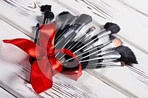 Makeup brushes tied of a red ribbon.