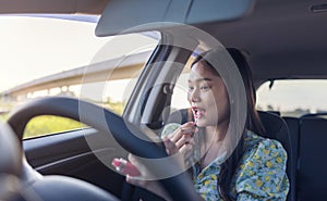 Makeup in the car, young woman applying makeup while driving