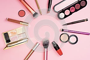 Makeup in close view. A lot of Cosmetics for woman on the backgroud. Cosmetics is stacked in a circle on the pink backgroud photo