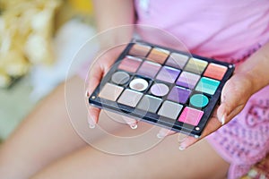 Makeup colorful eyeshadow palette in hands