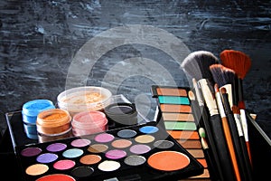 makeup cosmetics beauty tools and brushes infront of black wooden background photo