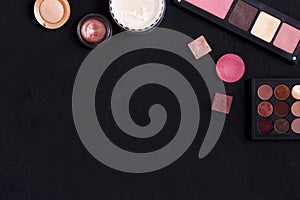 Makeup cosmetics essentials frame black background, copy space
