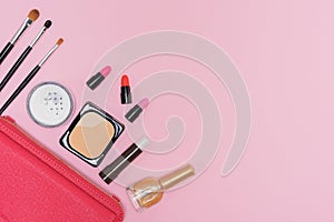 Makeup cosmetics palette and brushes on pink background flat lay