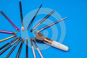 Set of various make up brushes on a blue background