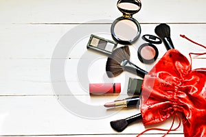 Makeup cosmetics in red bag on white background. Santa Claus gifts in a bag. Concept holidays.