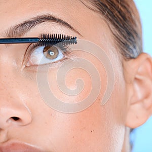 Makeup, mascara and eyelashes with a black woman in studio on a blue background for beauty. Eyes, cosmetics and zoom