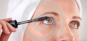 Makeup, mascara and face of woman with brush in studio for beauty, cosmetics or application. Eyelash, grey background or