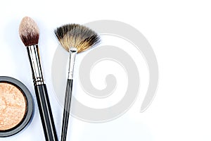 Makeup powder and brushes on white background