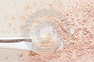 Makeup powder and white cosmetic brush. Light nude color matte foundation powder texture photo