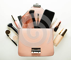 Makeup products with cosmetic bag on white background