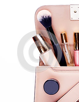 Makeup products with cosmetic bag on white background