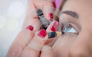 Makeup professional artist applying eyeshadow sticks on model eye