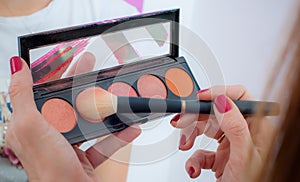Makeup professional artist applying powder blush