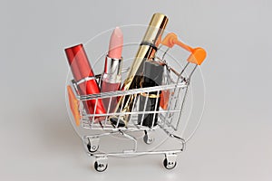 Makeup in pushcart on gray photo
