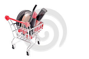 Makeup in pushcart isolated on white background. Red lipstick, mascara, pink lip gloss, powder, nail polish. Makeup