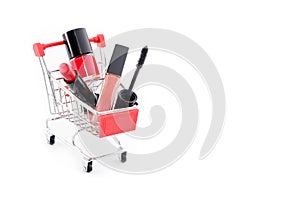 Makeup in pushcart isolated on white background. Red lipstick, mascara, pink lip gloss, powder, nail polish. Makeup