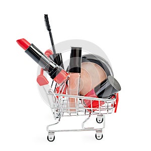 Makeup in pushcart on white background. Red lipstick, mascara, pink lip gloss, powder, nail polish. Makeup products in sh