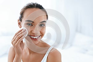 Makeup Remove. Girl Cleaning Face Skin With Cosmetic Pad photo