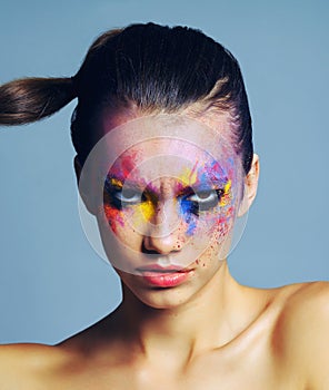 Makeup thats anything but meek. Studio shot of an attractive young woman with brightly colored makeup against a blue