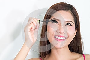 Makeup woman putting mascara eye make up on eyes. Asian fresh fa
