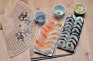 Maki sushi rolls and nigiri sushi with salmon and shrimp japan food on the table with soy sauce and ginger