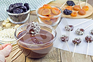 Making apricot and prunes lollipops with chocolate and macadamia nuts